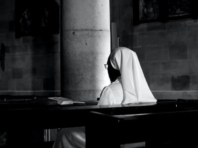 Veiled woman sitting on a bench in the grayscale images
